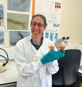 Lady in lab holding little pots
