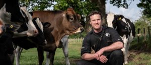 Rob Howe kneeling with some cattle